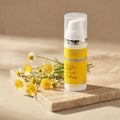 Bielenda Professional Supremelab Barrier Renew cream bottle next to a soft yellow wildflower and a natural smooth beige stone slab