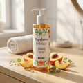 Anwen Peach and Coriander Shampoo on a bathroom vanity with fresh peaches